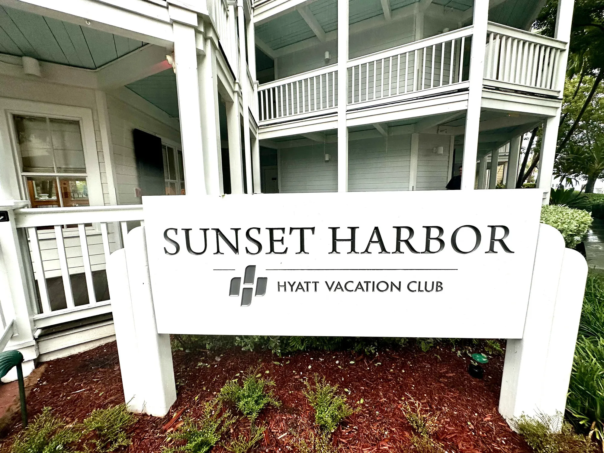 The Sunset Harbor entrance sign, the clapboard guest buildings and their balconies behind it