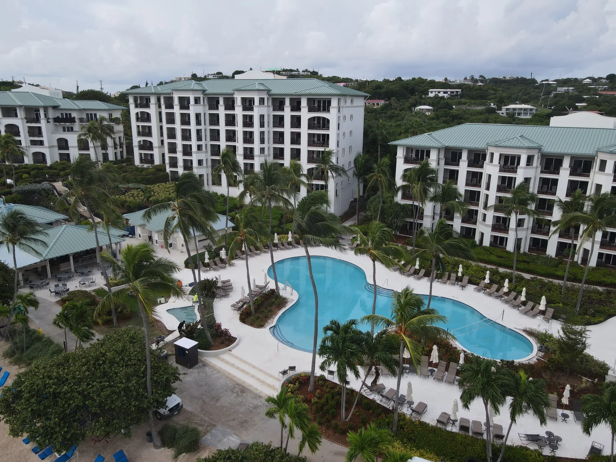 The resort's pool deck and grounds from the air, the guest-room buildings around them