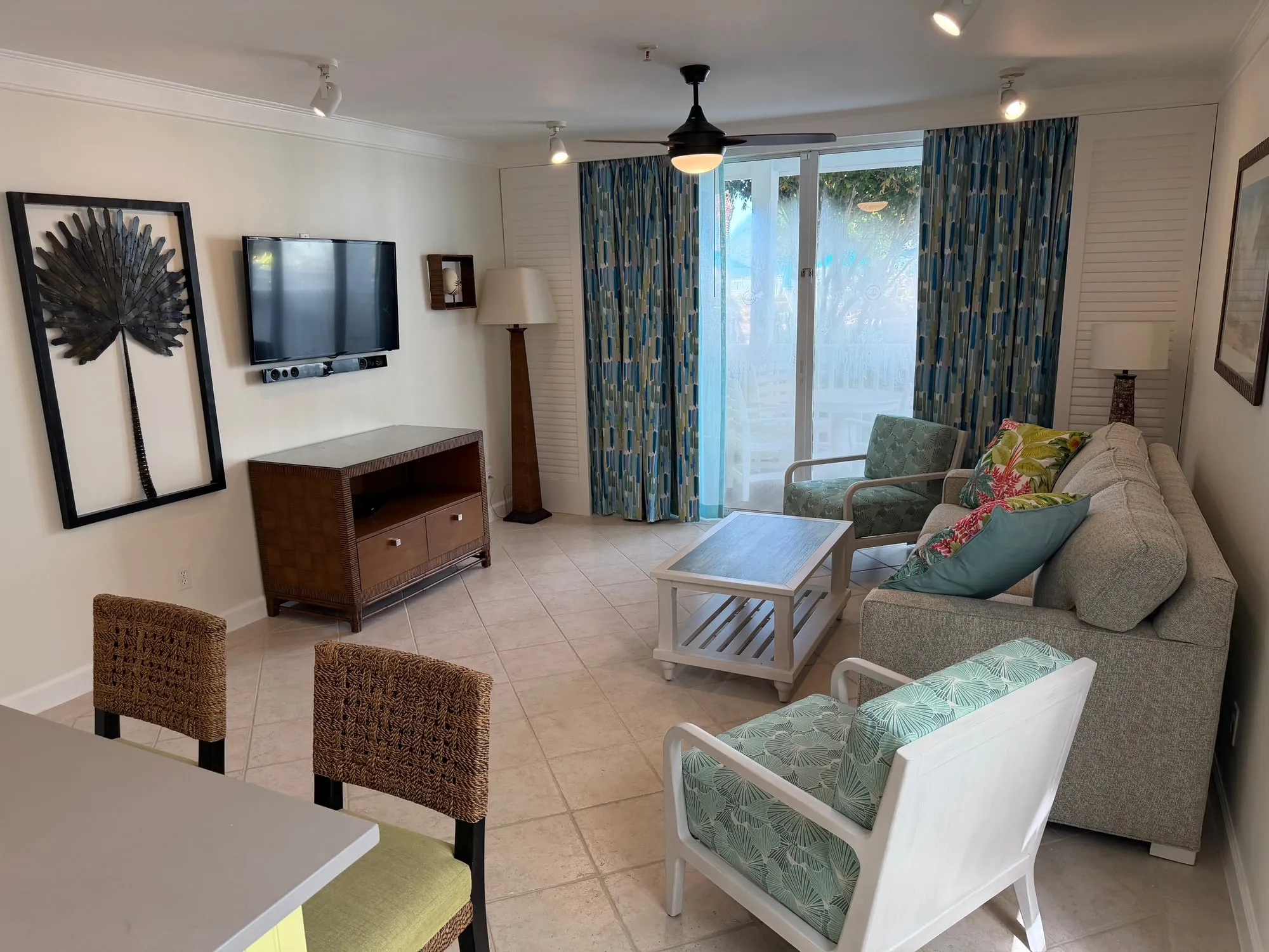 The same renovated unit from the dining end, the living area and balcony doors beyond