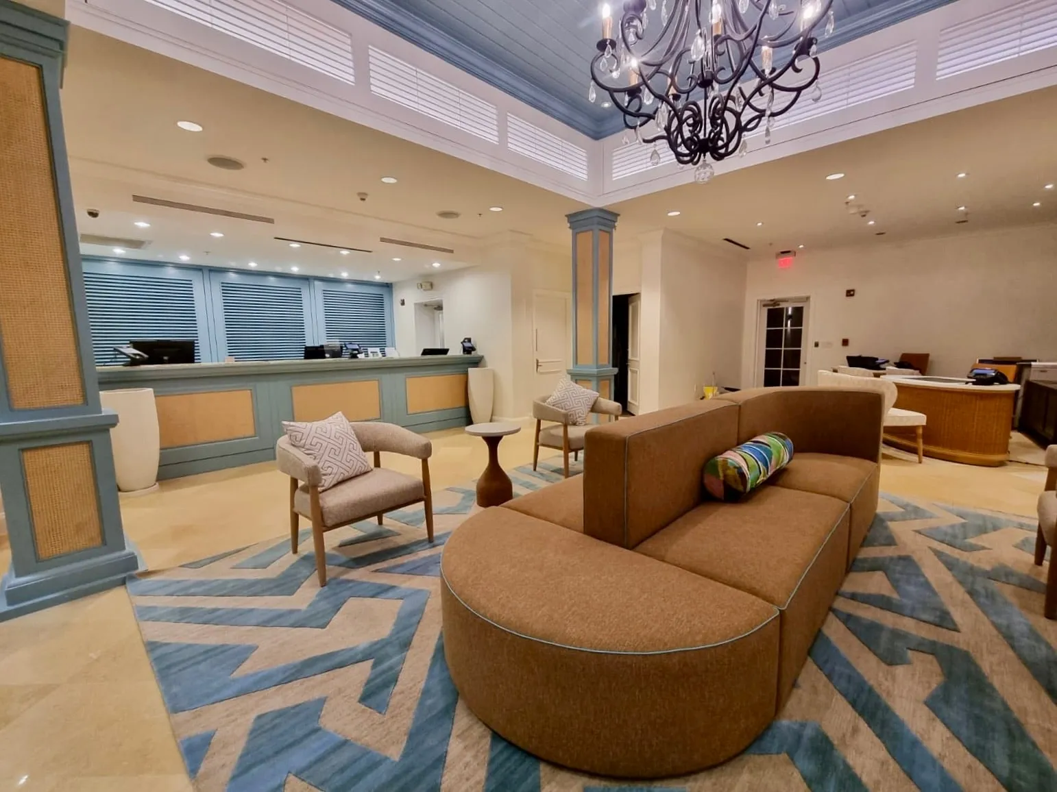 The lobby seating area after renovation, under the painted ceiling and chandelier