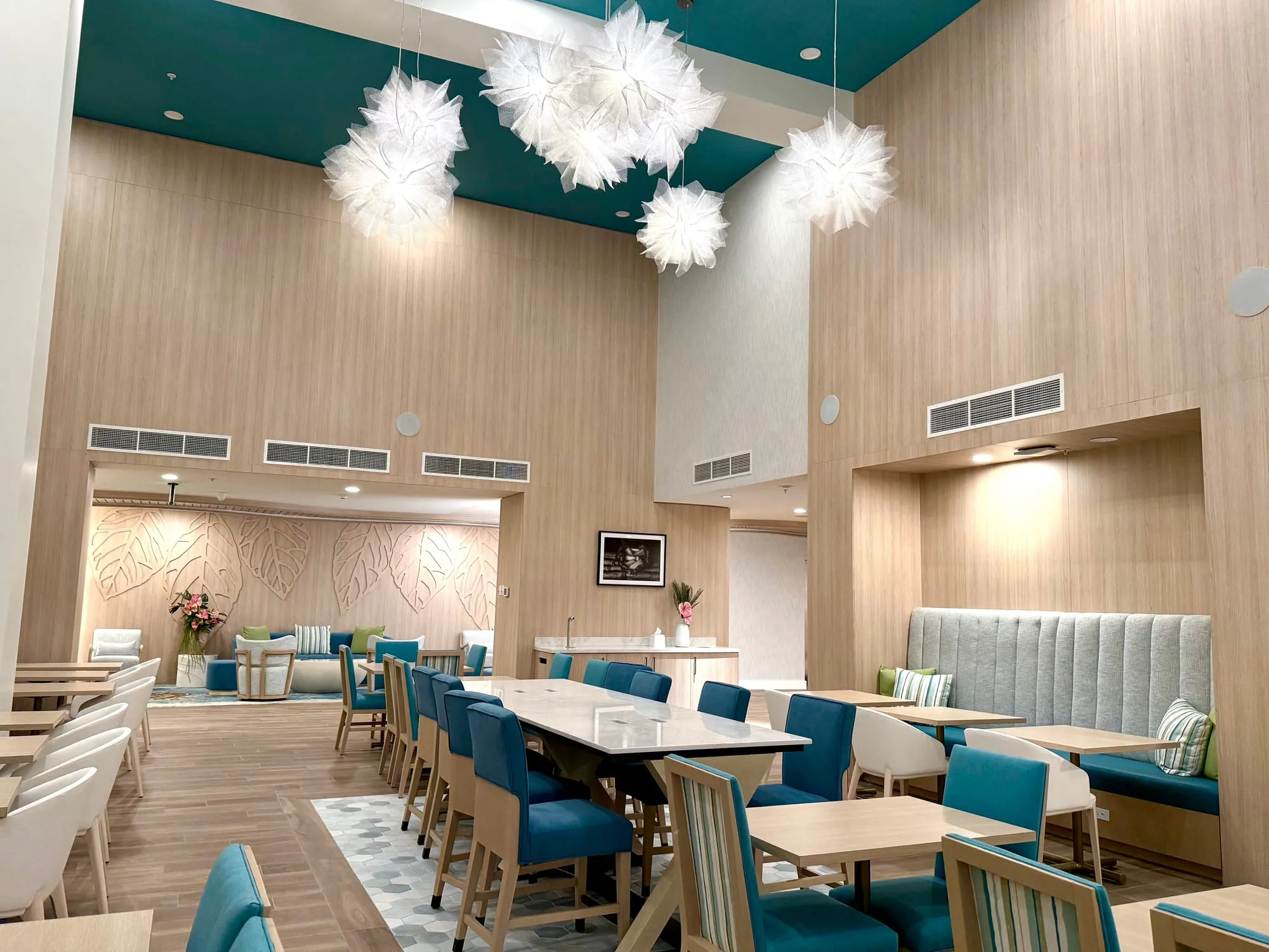 The same lobby dining area seen from the entrance, looking through to the lounge and the relief wall beyond