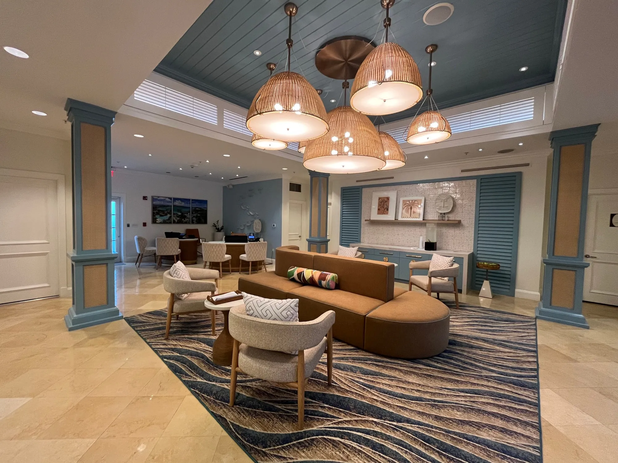 The renovated lobby, its seating and reception desks under the coffered ceiling