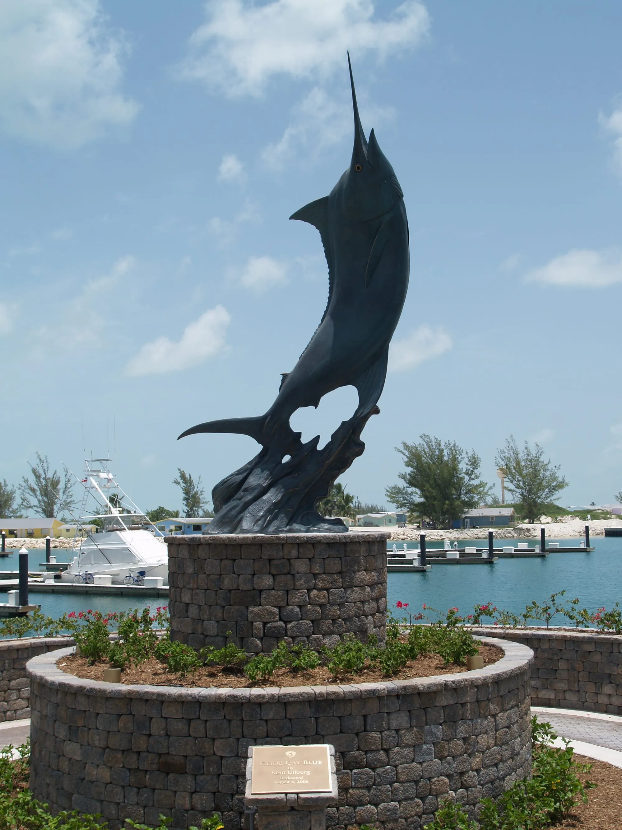 The marlin sculpture at the marina entrance, sportfishing boats on the dock behind