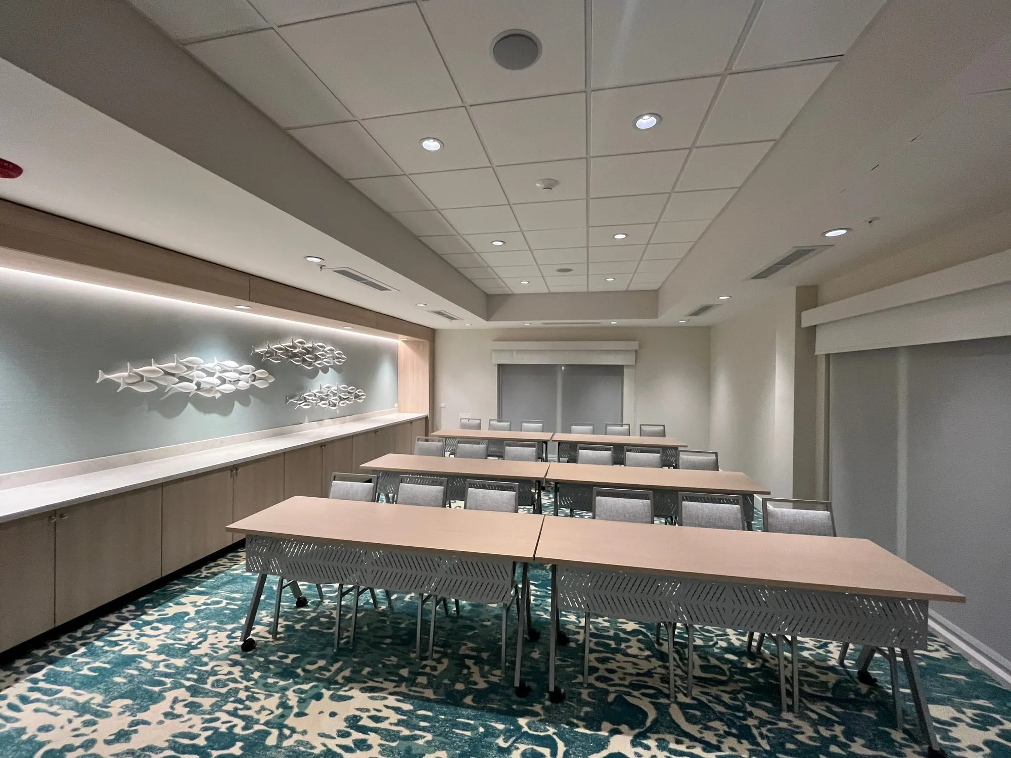 The finished hotel meeting room, with a long table and patterned carpet
