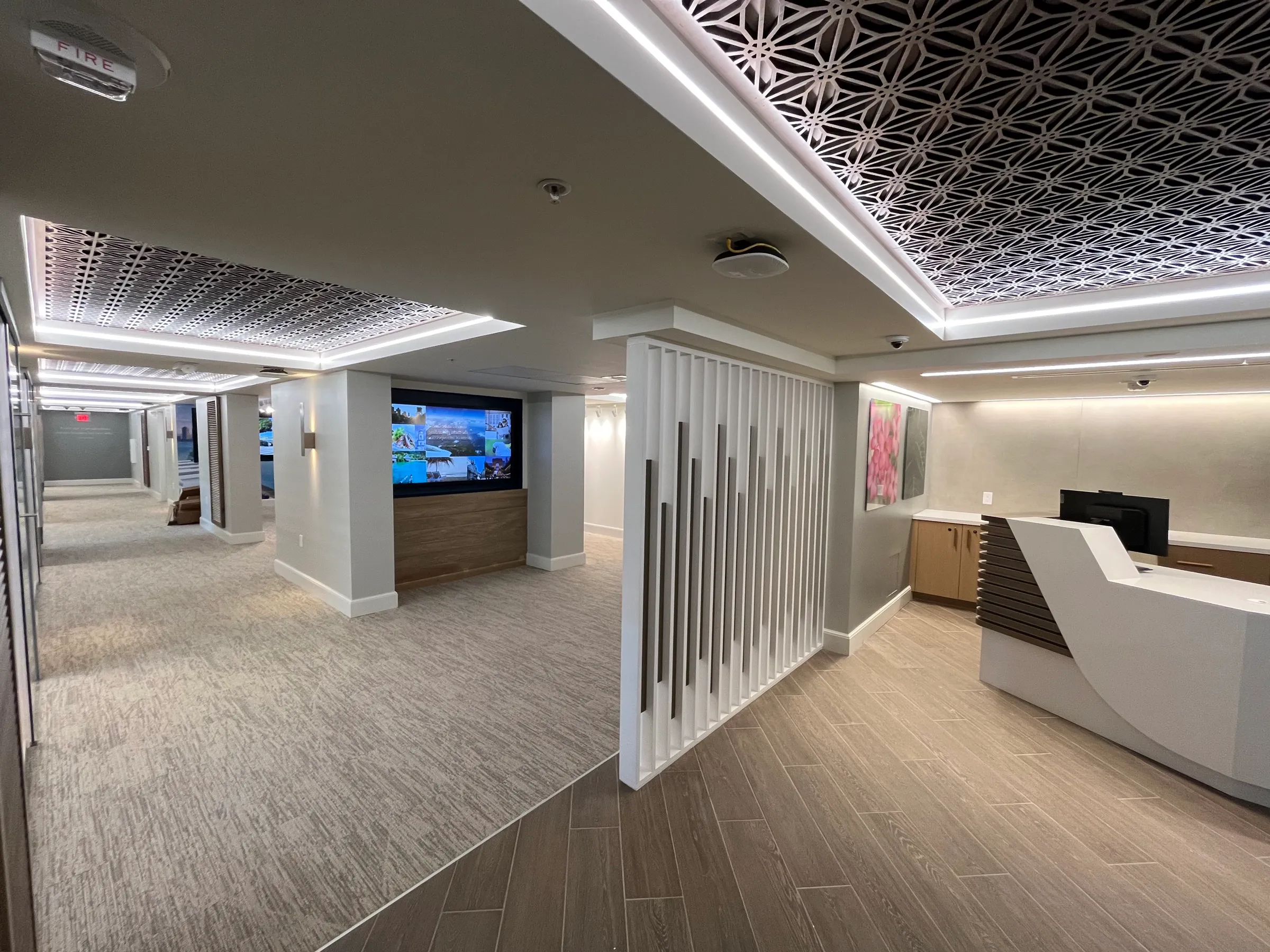 Reception fit-out Finished reception desk with a slatted partition and patterned ceiling