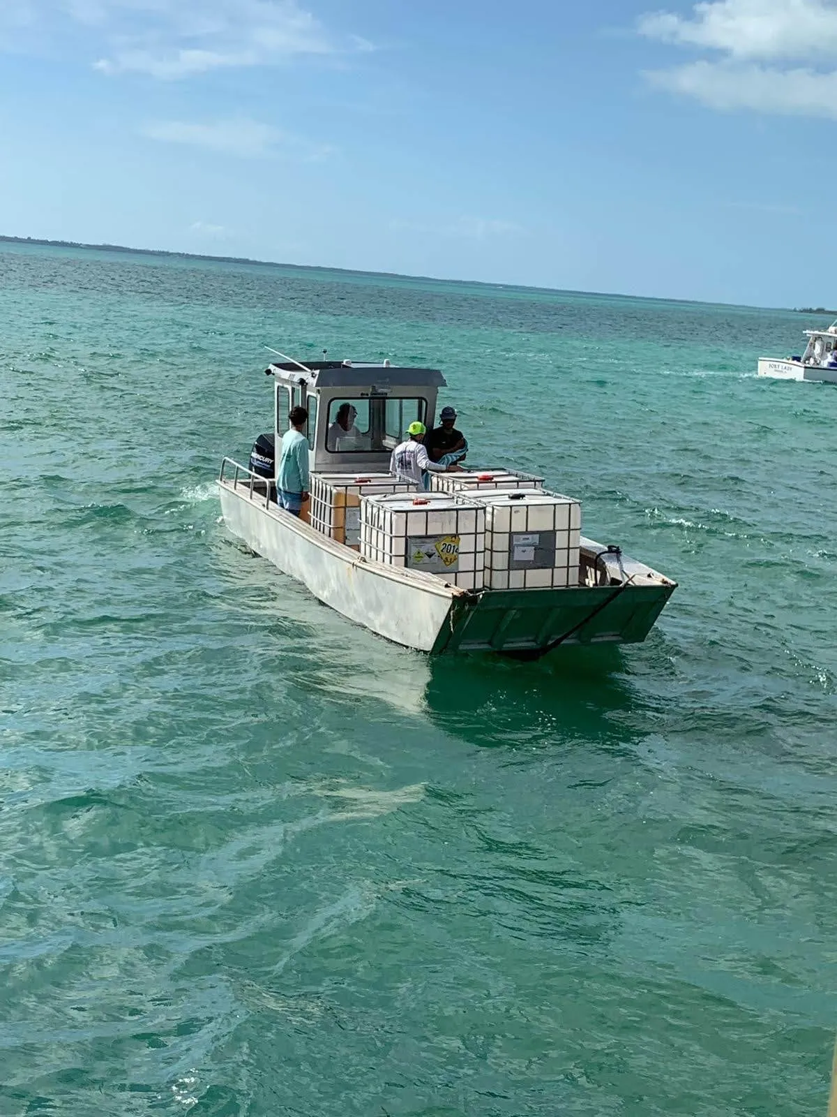A landing craft bringing palletised supplies across the flats to the island