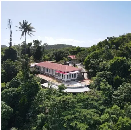 Red-roofed hillside building Aerial view of a red-roofed building in wooded hills