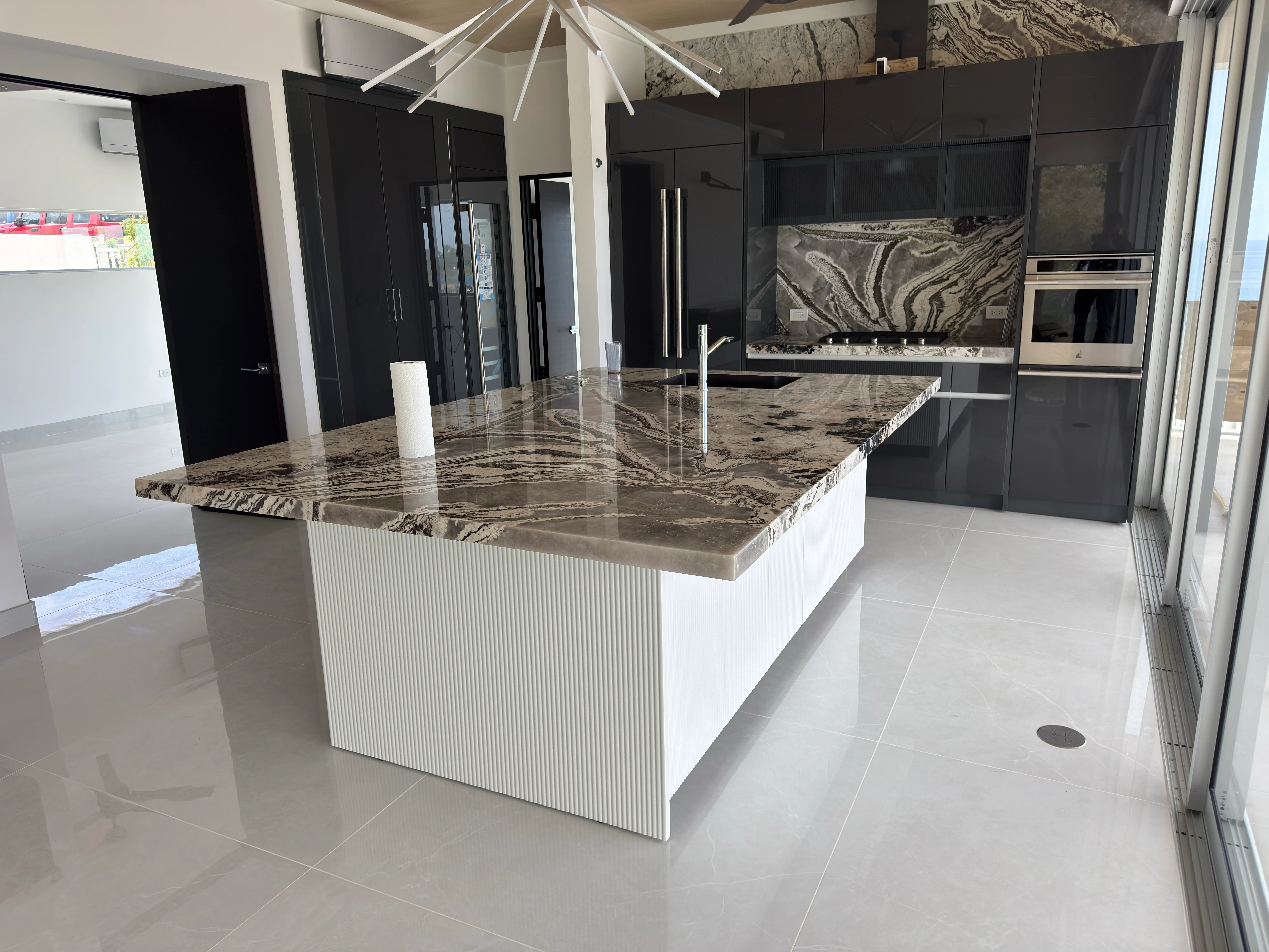 Private residence kitchen A finished island kitchen with a stone worktop and full-height glazing